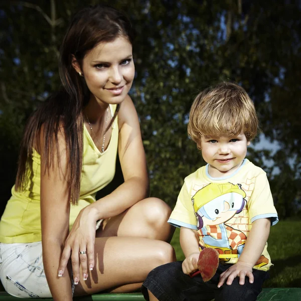 Young boy playing at home near house in garden with his mother — Stock Photo, Image