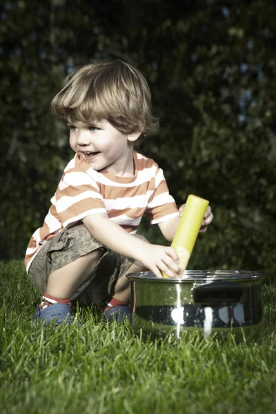Jonge jongen thuis spelen in de buurt van huis in tuin met verschillende speelgoed — Stockfoto