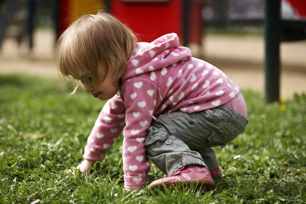 Petite fille dehors sur une aire de jeux jouant avec sa mère — Photo