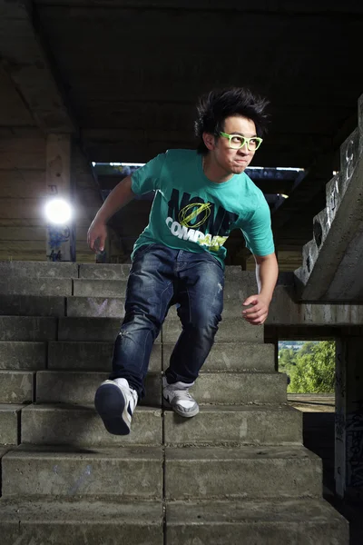 Jeune garçon asiatique posant pour des photos élégantes dans les ruines du bâtiment — Photo