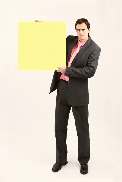 Man in suit holding yellow board — Stock Photo, Image