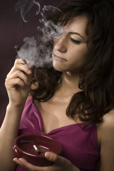 Молода жінка палить марихуану — стокове фото