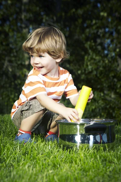 Jonge jongen thuis spelen in de buurt van huis in tuin met verschillende speelgoed — Stockfoto