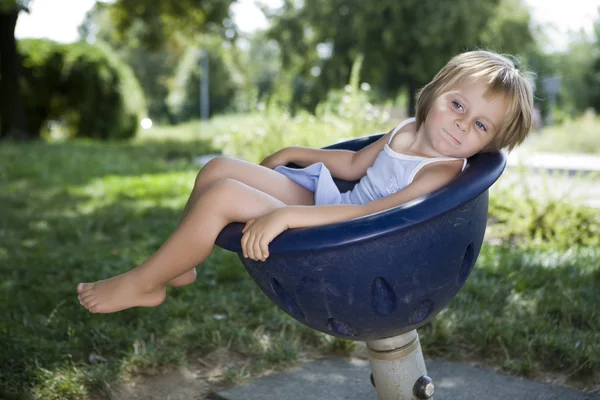 Dívka si hraje na dětské hřiště swing — Stock fotografie