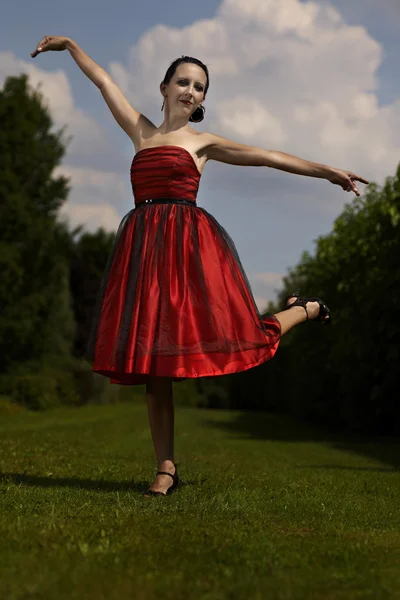 Senhora de vestido vermelho posando no jardim — Fotografia de Stock