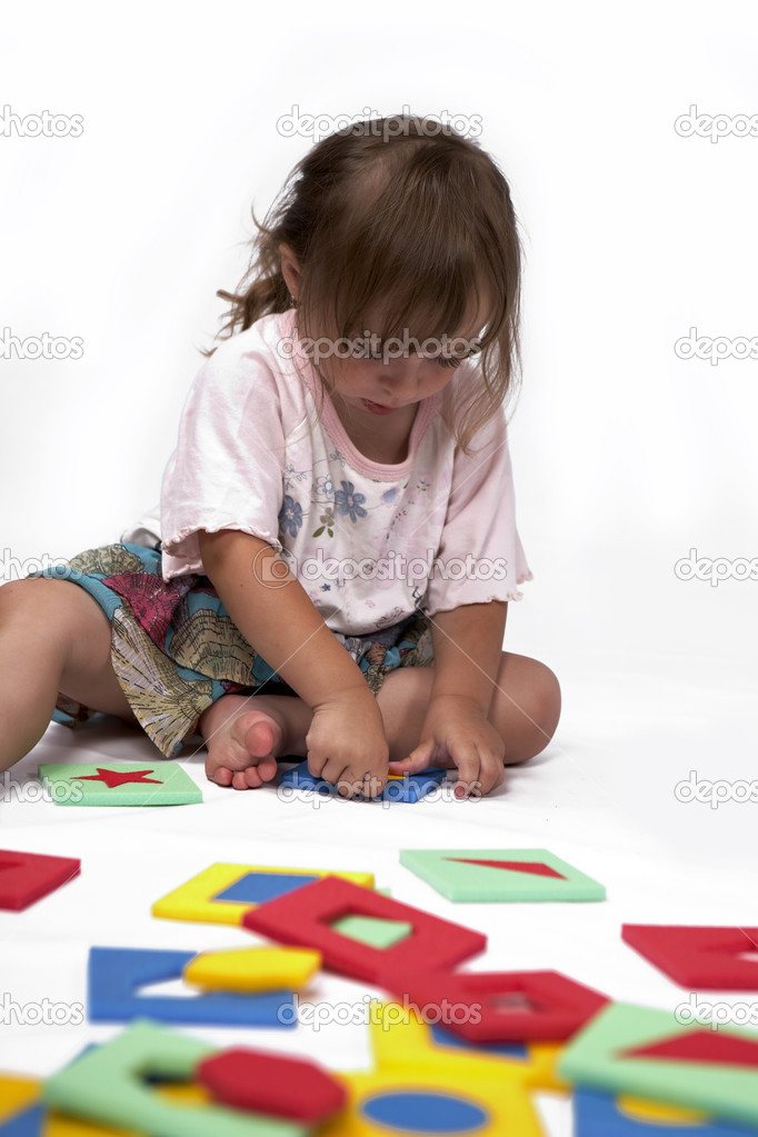 Girl at play with set of rubber foam toys