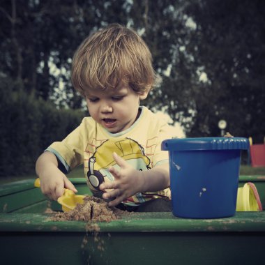 Genç çocuk evde Bahçe house civarındaki çeşitli oyuncaklar ile oynama