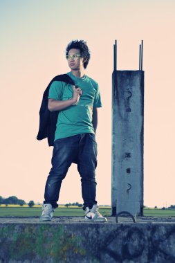 Genç Asyalı çocuk posingfor şık fotoğraf bina kalıntıları içinde