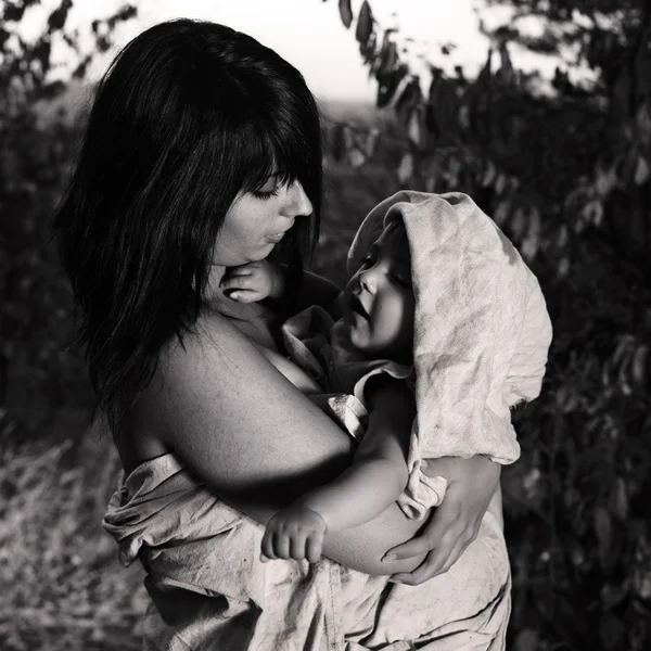 Jonge dame met baby op buitenkant locatie in lompen takong zorg voor haar kind — Stockfoto