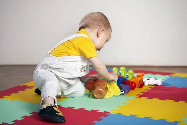 Niño jugando al interior en el suelo de madera — Foto de Stock