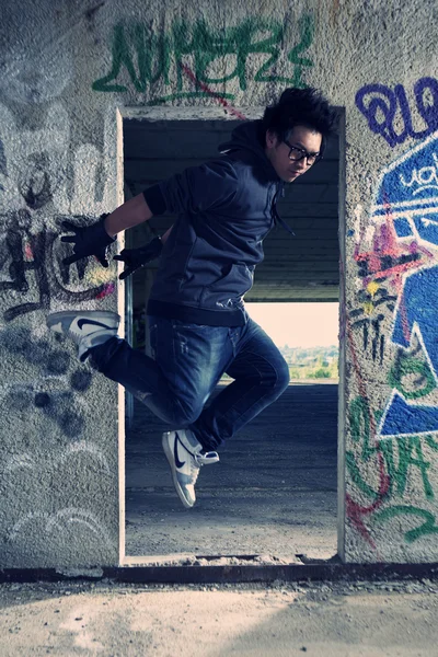 Jeune garçon asiatique posant pour des photos élégantes dans les ruines du bâtiment — Photo