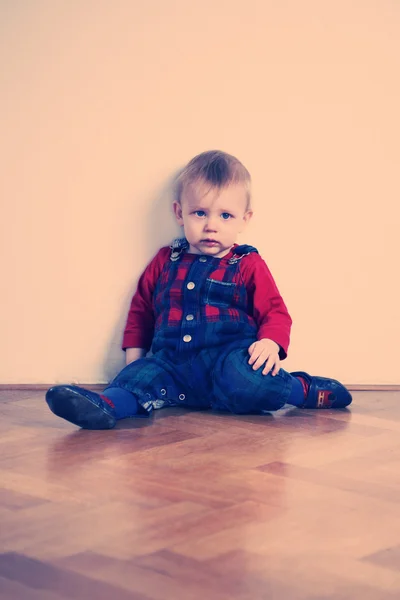 Young boy playing indoor on wooden floor — Stock Photo, Image