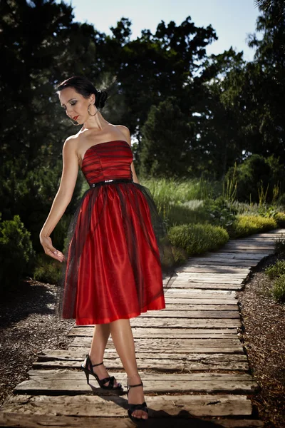 Bahçede poz Kırmızı elbiseli Bayan — Stok fotoğraf