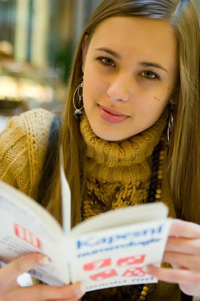 Winter time - nice lady relaxing in winter time in shopping mall coffee drinking juice and reading book — Stock Photo, Image