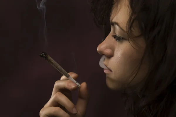 Молода жінка палить марихуану — стокове фото