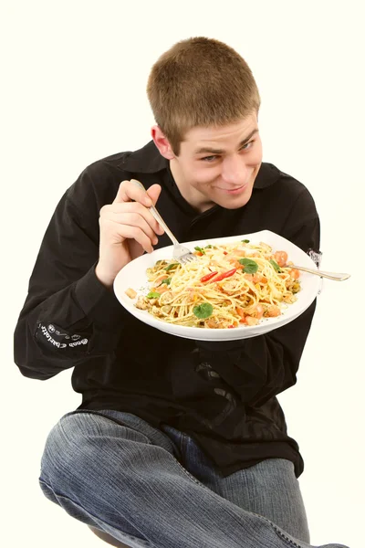 Junger Mann isst Pasta — Stockfoto