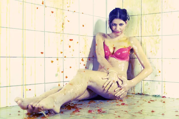 Mujer joven jugando con gelatina derretida en la sala de baldosas blancas — Foto de Stock