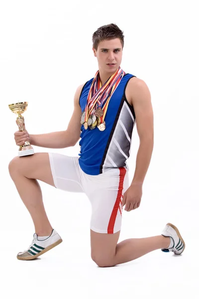 スポーツの多くのメダルとカップを持つ男 — ストック写真