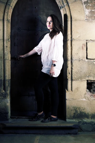 Young busty lady posing outdoor by the church for portraits in white top — Stock Photo, Image