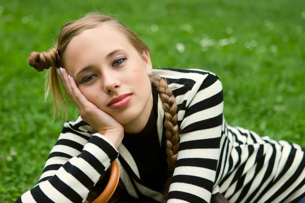 Lady posing in summer city park in striped dress — Stock Photo, Image