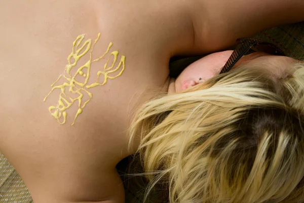 Hermosa mujer joven baño de sol y crema en la espalda - dibujar el cáncer — Foto de Stock