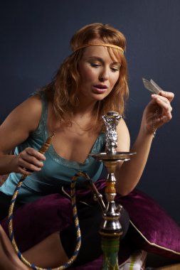 Genç kadın nargile içiyor.