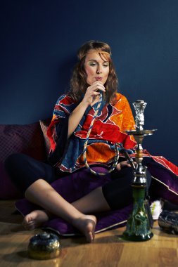 Genç kadın nargile içiyor.