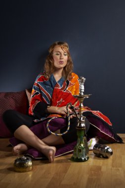 Genç kadın nargile içiyor.