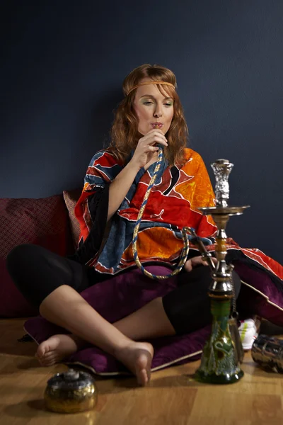 Genç kadın nargile içiyor.