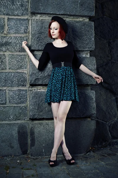 Pretty girl in city posing by wall — Stock Photo, Image