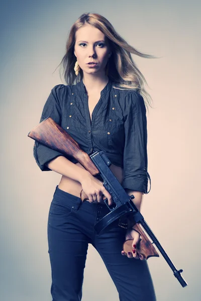 Девушка позирует с пистолетом — стоковое фото
