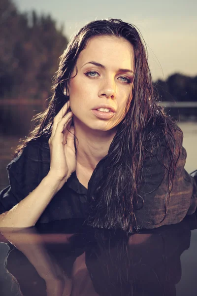 Ung kvinnlig modell poserar på sommaren vid sjön — Stockfoto