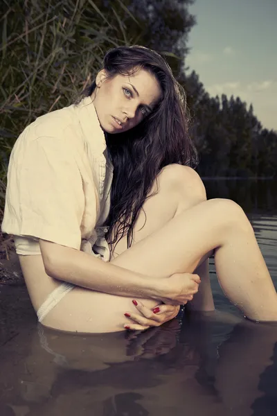 Jovem modelo feminino posando na hora de verão junto ao lago — Fotografia de Stock