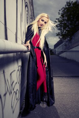 sarışın kız siyah pelerin içinde poz