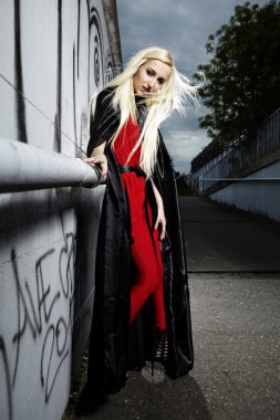 sarışın kız siyah pelerin içinde poz