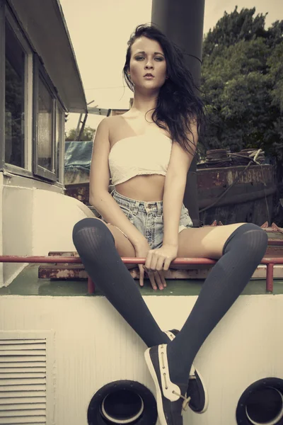 Brunette girl posing on berth — Stock Photo, Image