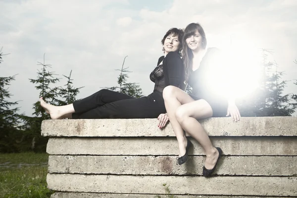 Two friends sitting on a concrete slab — Stock Photo, Image