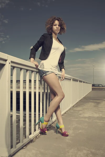 Curly girl posing on the bridge — Stock Photo, Image