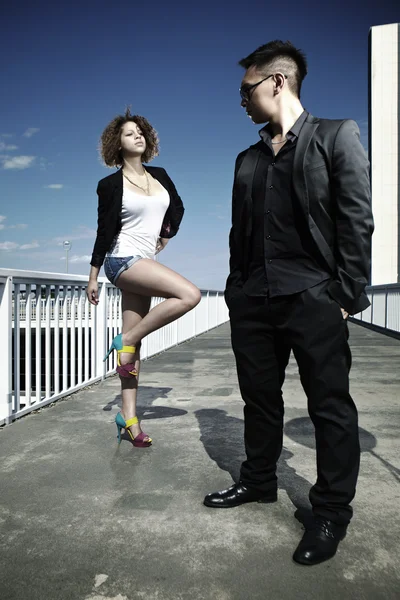 Casal posando em uma ponte na cidade — Fotografia de Stock