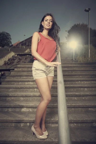 Brunette girl posing on the stairs — Stock Photo, Image