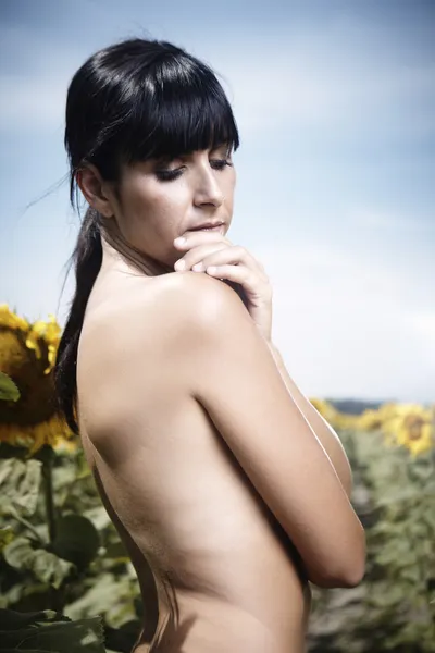 Ayçiçeği tarlası içinde çıplak esmer kız — Stok fotoğraf