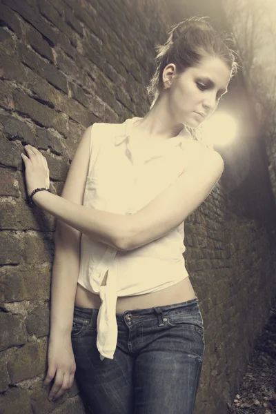 Brunette girl near the wall — Stock Photo, Image