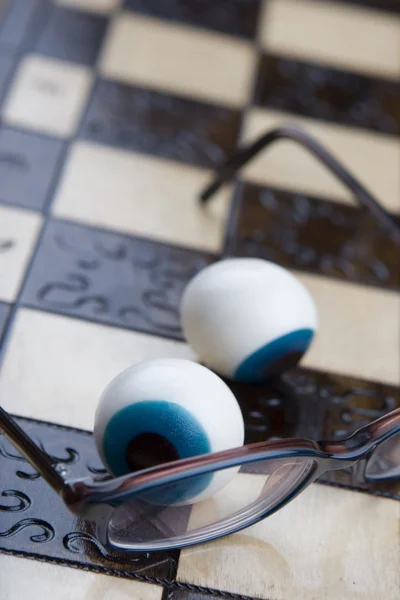 Очки на шахматной доске — стоковое фото