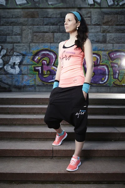 Brunette girl in fitness dress posing in city — Stock Photo, Image