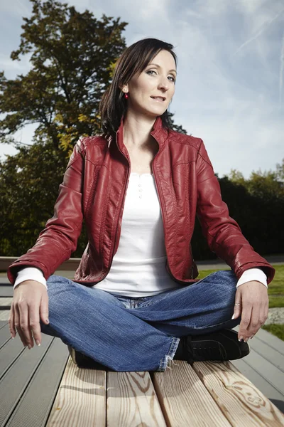 Relaxing pretty woman sitting in park — Stock Photo, Image