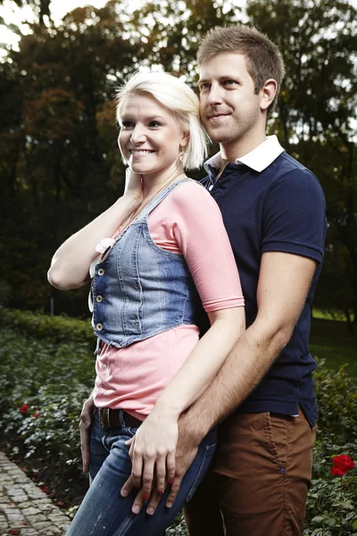 Souriant beau couple dans le parc d'automne — Photo