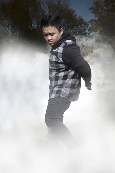 Asian man dancing in smoke — Stock Photo, Image