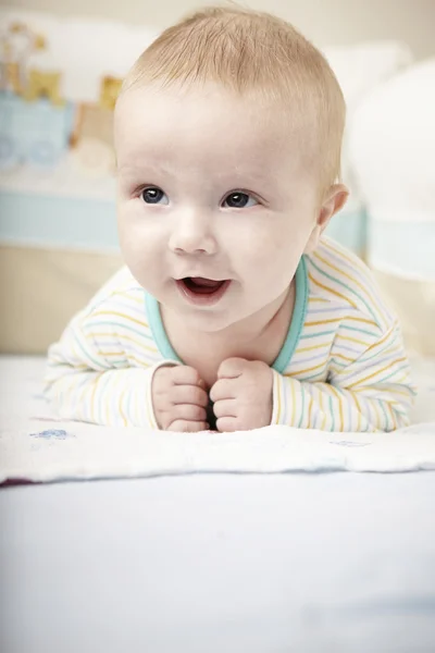 Mignon jeune garçon sur le lit — Photo