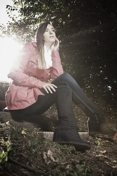 Chica en otoño luz sentado en el bosque — Foto de Stock