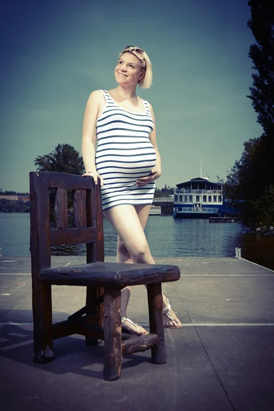 Pretty pregnant lady on river bank — Stock Photo, Image